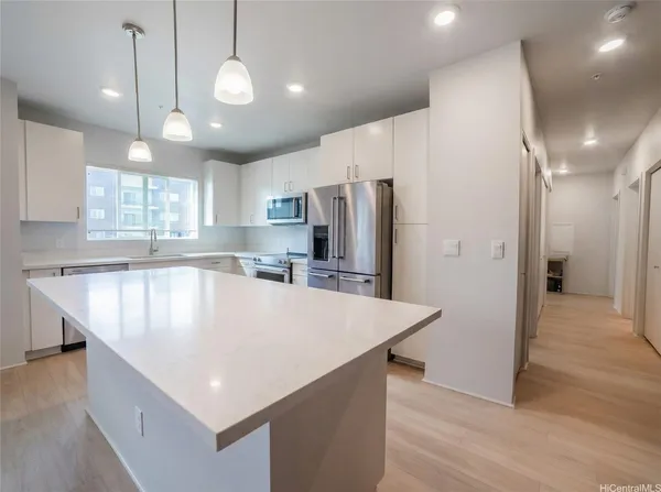 a large kitchen with stainless steel appliances a refrigerator a stove a sink and a center island