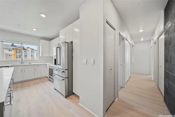 a kitchen with white cabinets and stainless steel appliances