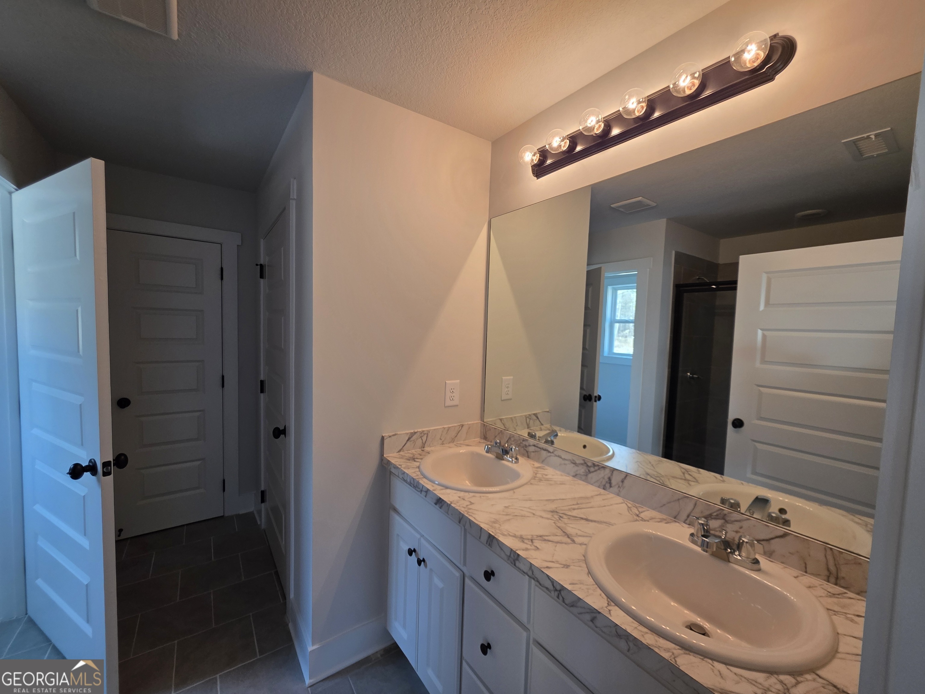 1167 Jeannine Lane, Unit 15 Winder, GA 30680 - Photo 13 of 14 a bathroom with a granite countertop sink and a mirror