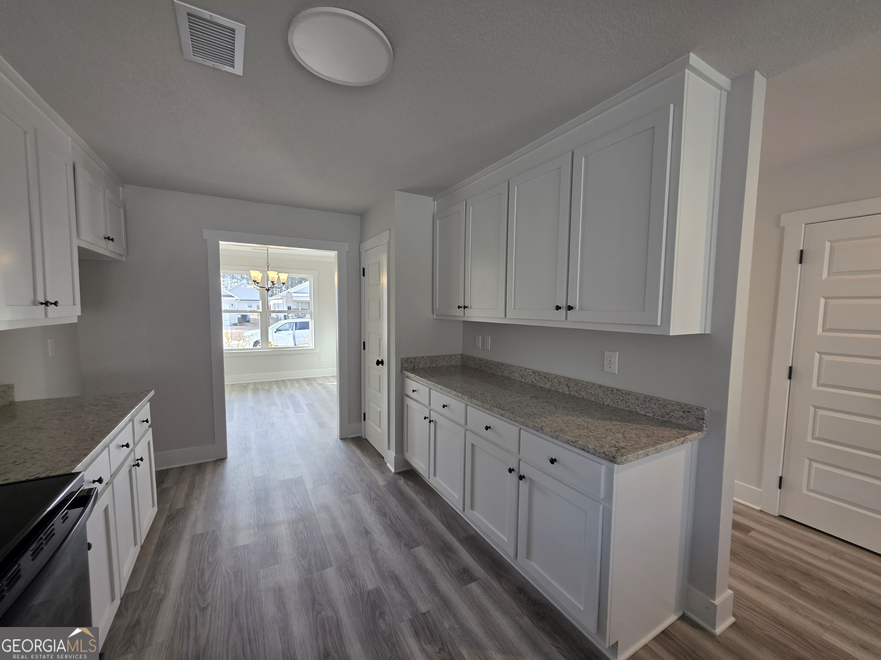 1167 Jeannine Lane, Unit 15 Winder, GA 30680 - Photo 3 of 14 a kitchen with cabinets a sink and wooden floor