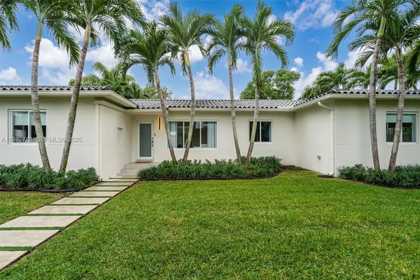 a front view of a house with a garden