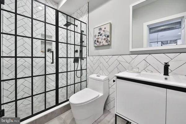 a white toilet sitting next to a white wall
