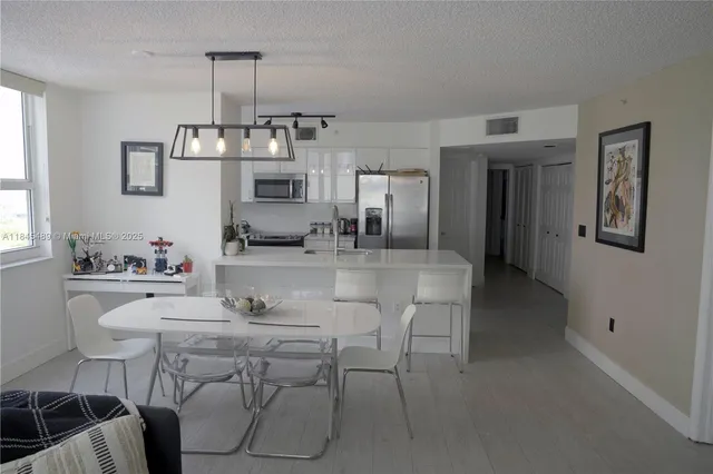 a kitchen with stainless steel appliances a refrigerator a sink a stove and cabinets