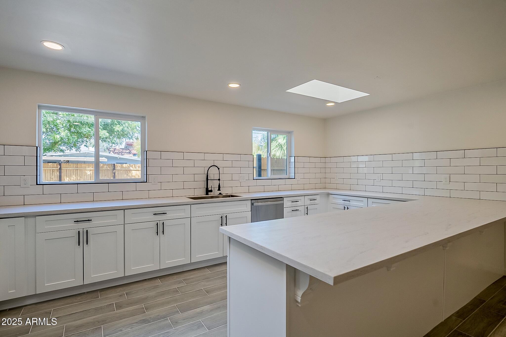 a kitchen with a sink cabinets and wooden floor