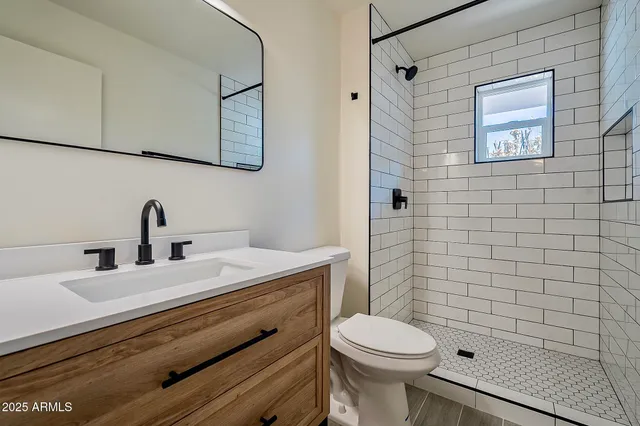 an empty room with wooden floor ceiling fan and window