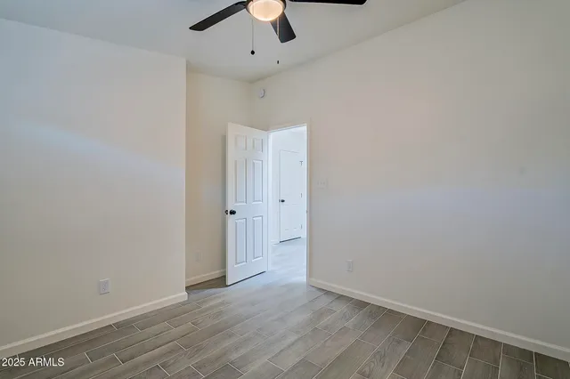a view of a big room with wooden floor and a ceiling fan