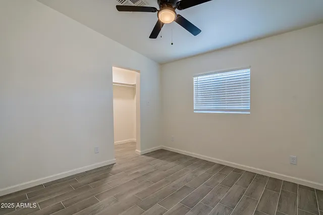 a view of an empty room with a ceiling fan