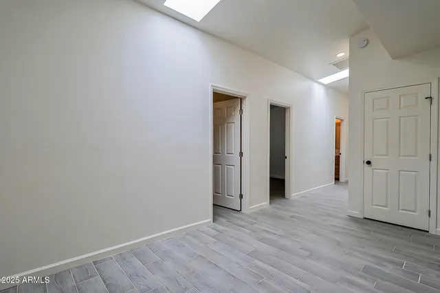 an empty room with wooden floor and ceiling fan