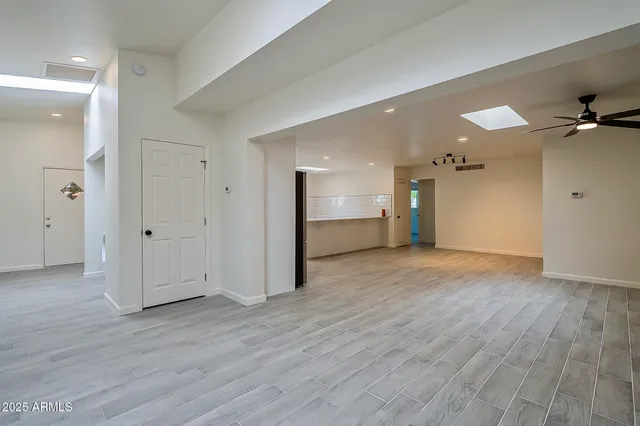 a view of an empty room and a ceiling fan