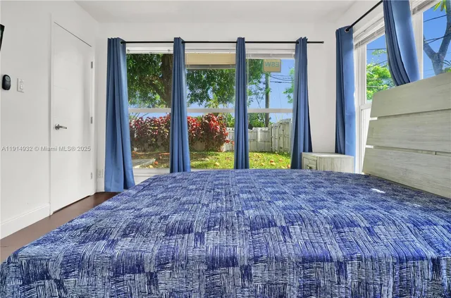 a view of a big room with a bed and wooden floor