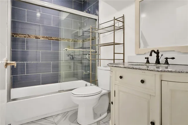 a bathroom with a bathtub shower sink vanity and toilet