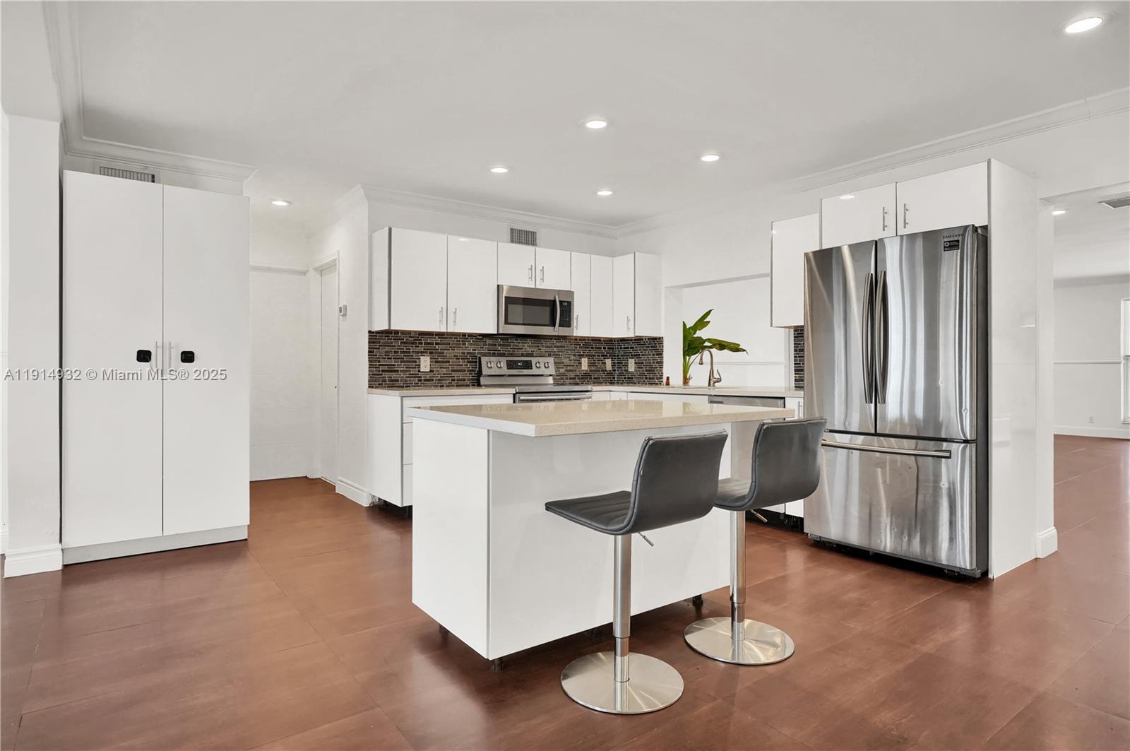 4721 West Park Road Hollywood, FL 33021 - Photo 9 of 34 a kitchen with stainless steel appliances granite countertop a refrigerator a stove a sink and a dining table with wooden floor