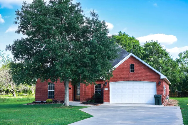 a front view of a house with a yard and trees