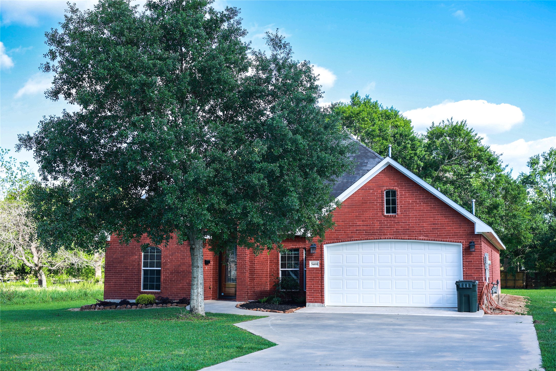 a front view of a house with a yard and trees