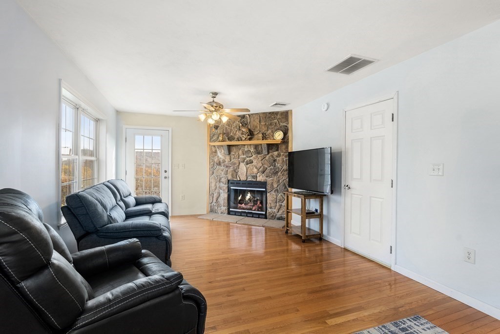 597 Old Warren Road Palmer, MA 01069 - Photo 13 of 37 a living room with fireplace furniture and a wooden floor