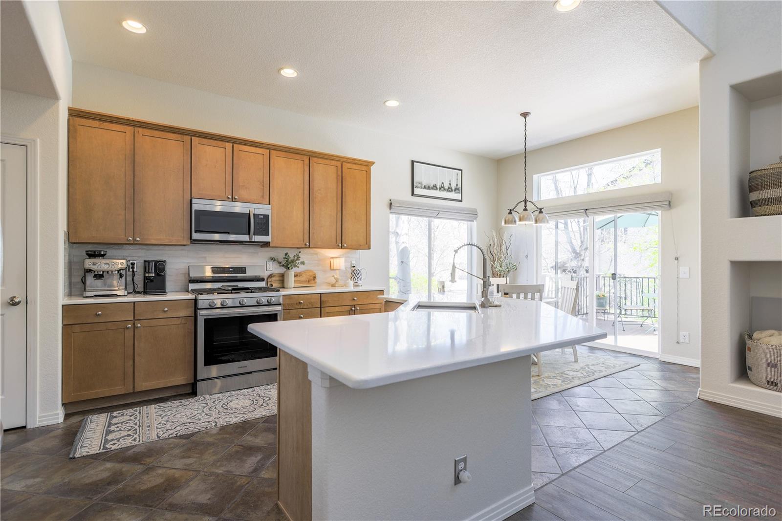3754 Broadview Place Castle Rock, CO 80109 - Photo 9 of 43 a large kitchen with kitchen island a large counter top space a sink stainless steel appliances and cabinets