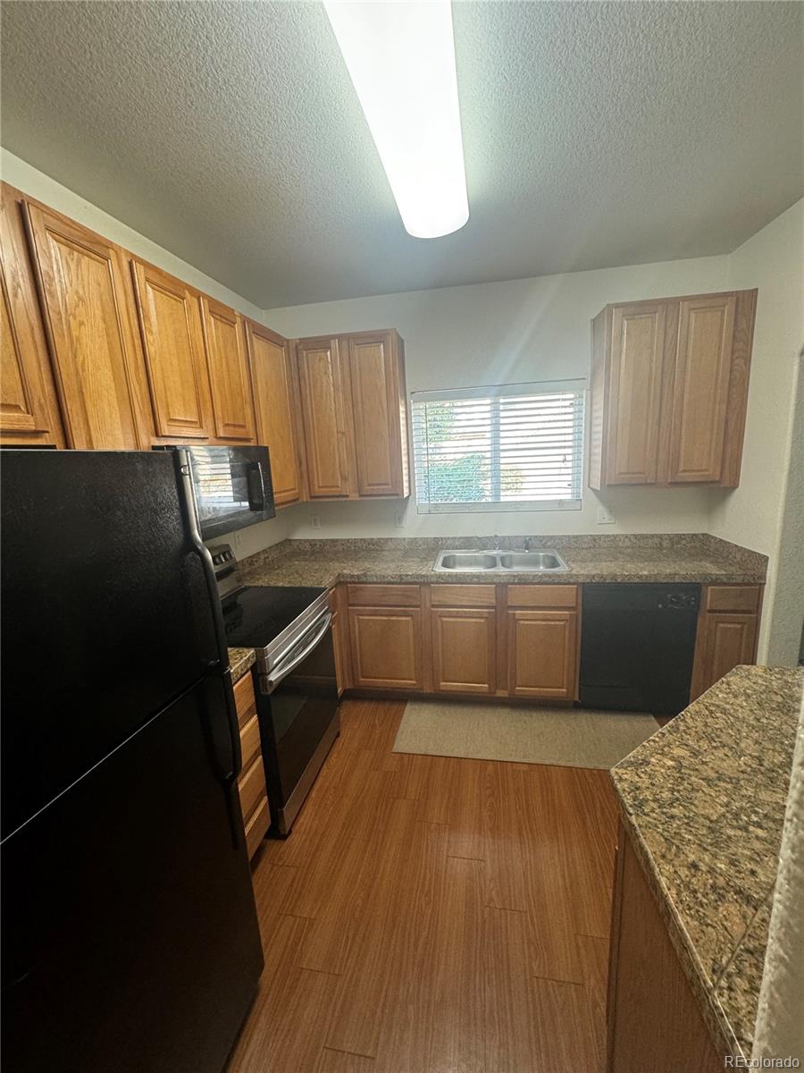 4730 Copeland Circle, Unit 101 Highlands Ranch, CO 80126 - Photo 6 of 14 a kitchen with a sink a window and cabinets