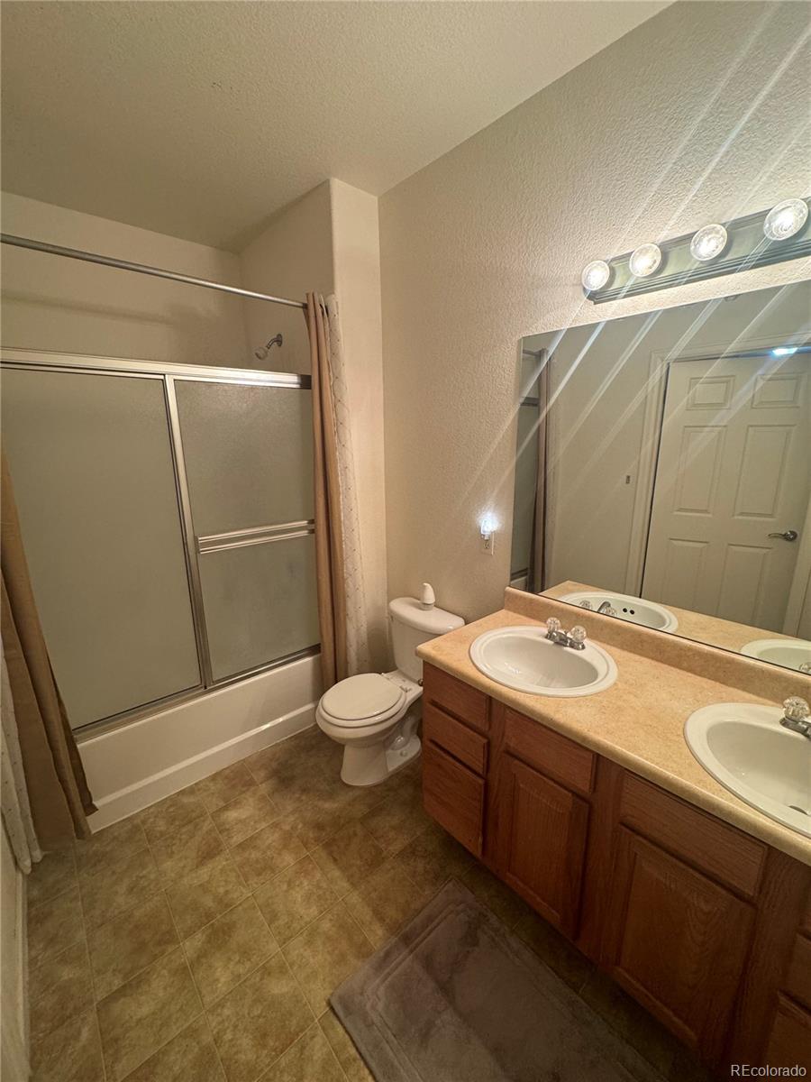 4730 Copeland Circle, Unit 101 Highlands Ranch, CO 80126 - Photo 7 of 14 a bathroom with a sink toilet and shower