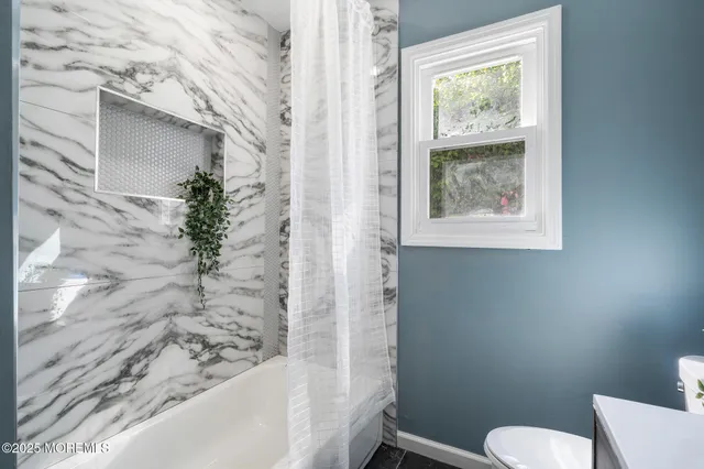 a bathroom with a toilet and a shower