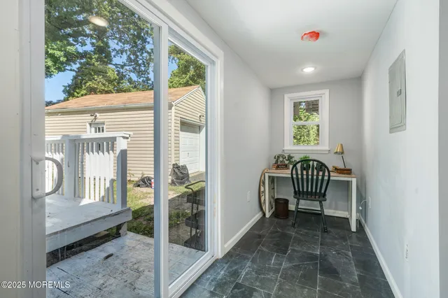 a view of a hallway with wooden floor and windows