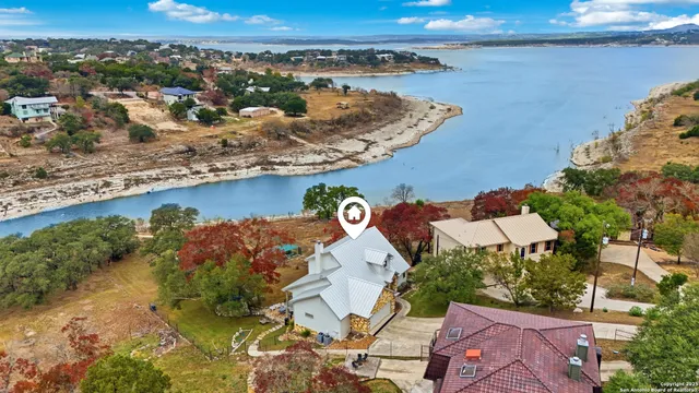 an aerial view of a house with a yard and lake view