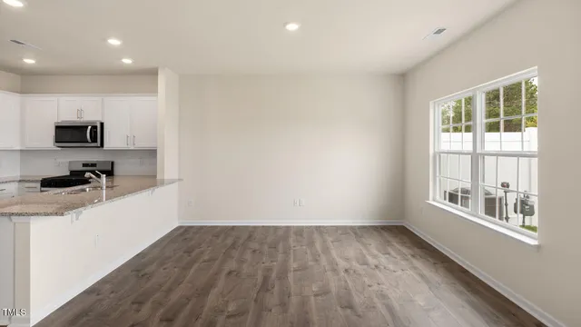a view of a kitchen with wooden floor and electronic appliances