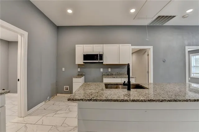 a large white kitchen with a stove and a sink