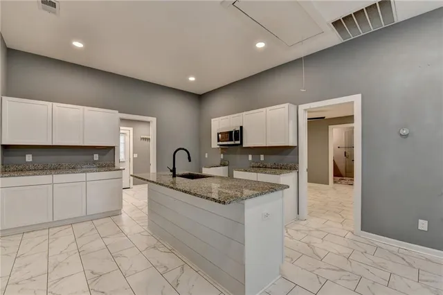 a large kitchen with stainless steel appliances granite countertop a sink and cabinets