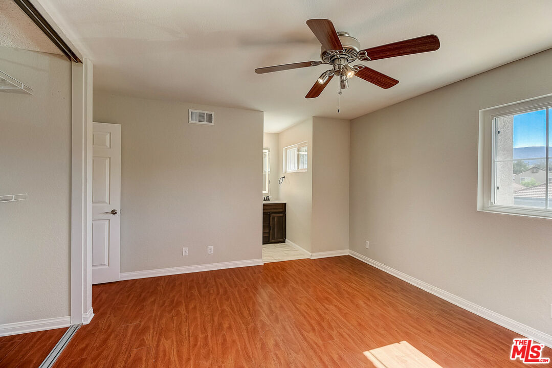 2137 Crosscreek Avenue Simi Valley, CA 93063 - Photo 21 of 31 an empty room with wooden floor ceiling fan and windows