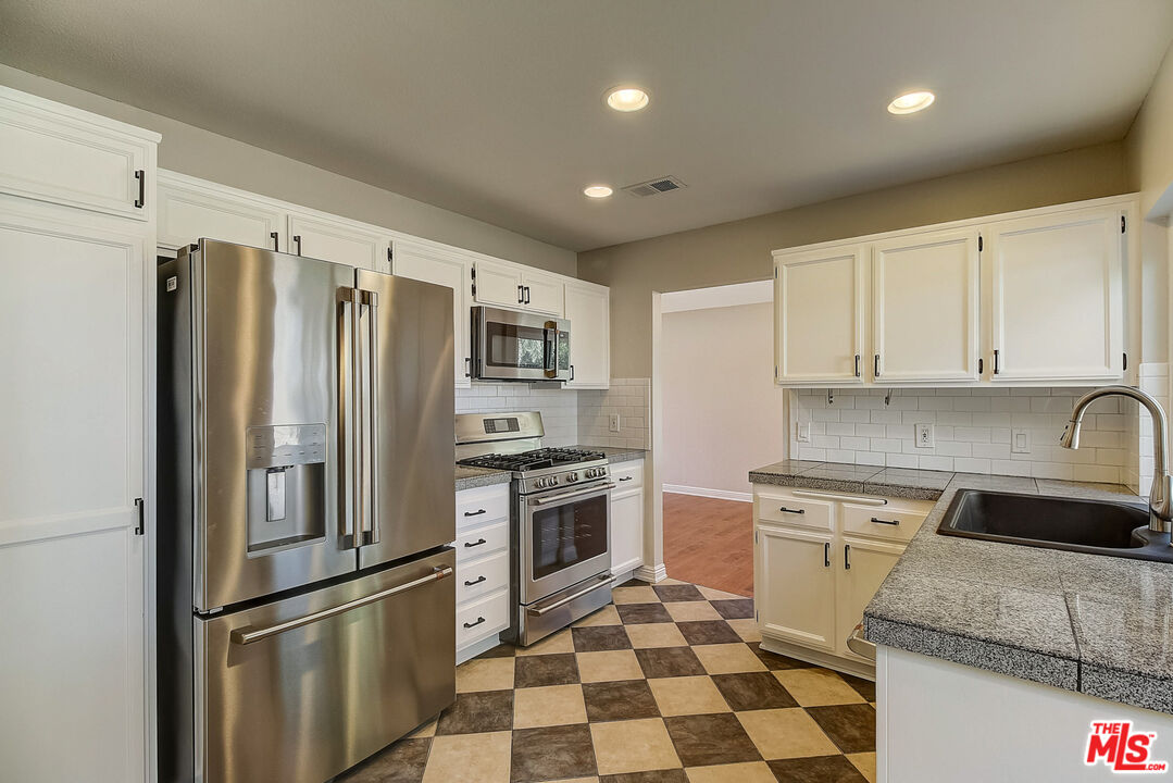 2137 Crosscreek Avenue Simi Valley, CA 93063 - Photo 4 of 31 a kitchen with stainless steel appliances granite countertop a refrigerator sink and stove