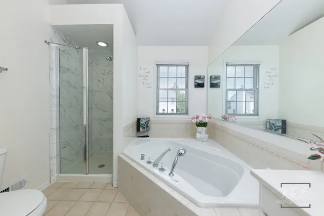 a bathroom with a granite countertop tub a sink and a shower