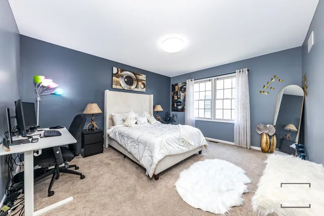 a bedroom with a bed a table window and chair