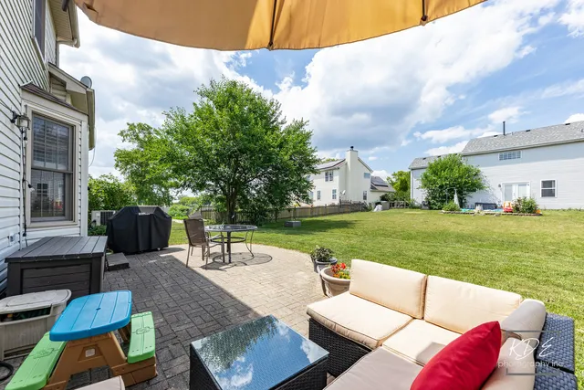 a view of a patio with couches chairs and a big yard