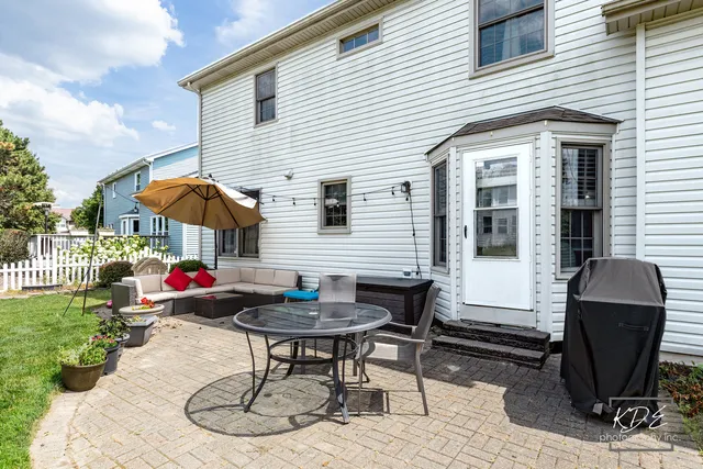 a backyard of a house with table and chairs