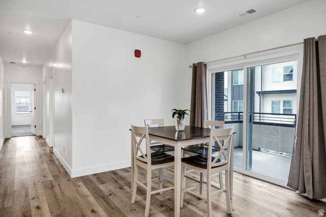 3115 South 200 West, Unit C201 Nibley, UT 84321 - Photo 6 of 23 Dining area featuring wood-finish flooring, recessed lighting, and a sliding glass door opening to a private balcony