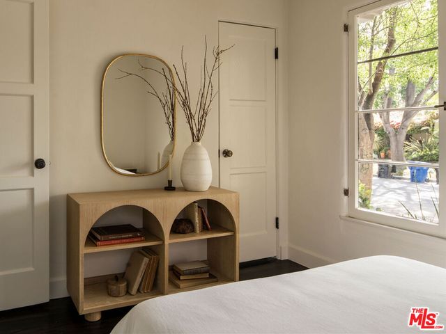 a bedroom with a bed and a painting on the wall