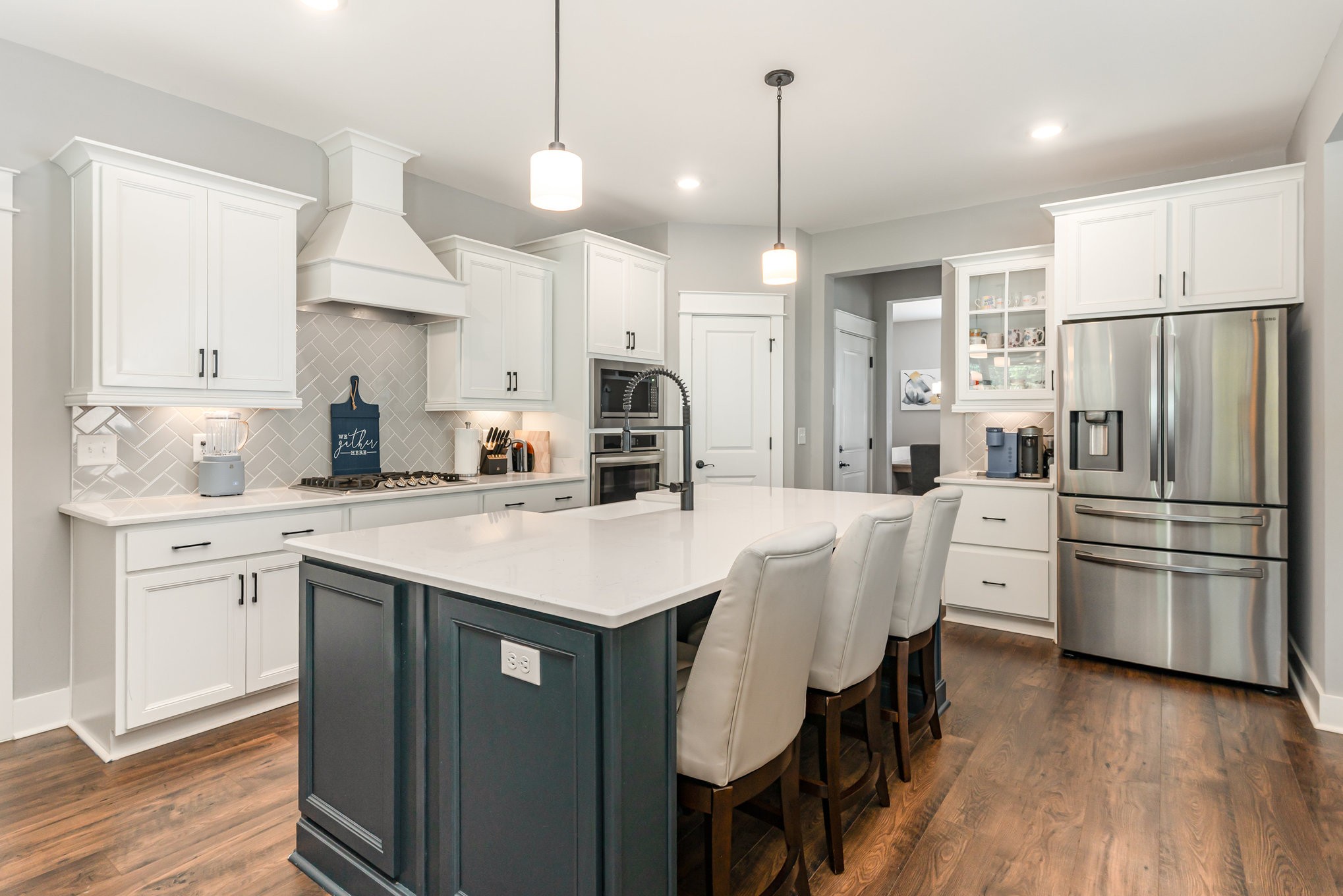 203 Caroline Way Mount Juliet, TN 37122 - Photo 12 of 37 a kitchen with stainless steel appliances a stove a sink a refrigerator a center island a stove and white cabinets with wooden floor