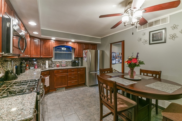 10818 Austin Avenue Chicago Ridge, IL 60415 - Photo 5 of 16 a kitchen with stainless steel appliances granite countertop a stove a sink dishwasher a dining table and chairs with wooden cabinets