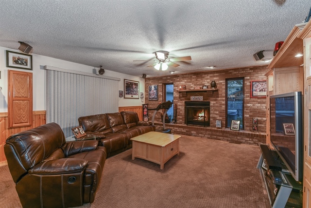 10818 Austin Avenue Chicago Ridge, IL 60415 - Photo 7 of 16 a living room with furniture a fireplace and a ceiling fan