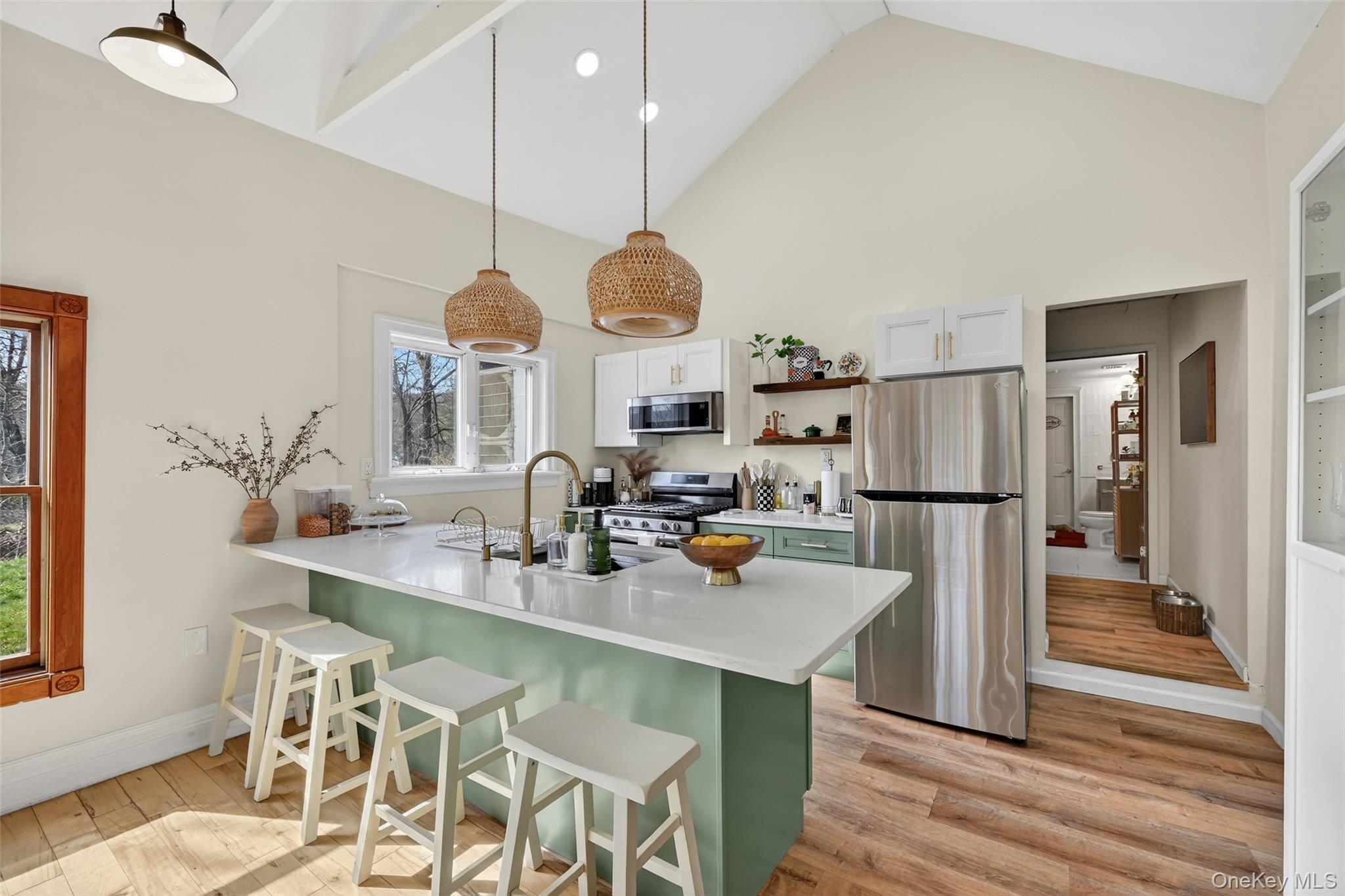 96 Lower Wisner Road Warwick, NY 10990 - Photo 6 of 34 Vaulted ceilings featuring exposed beams over a kitchen with a waterfall island, stainless steel appliances, and a gas range
