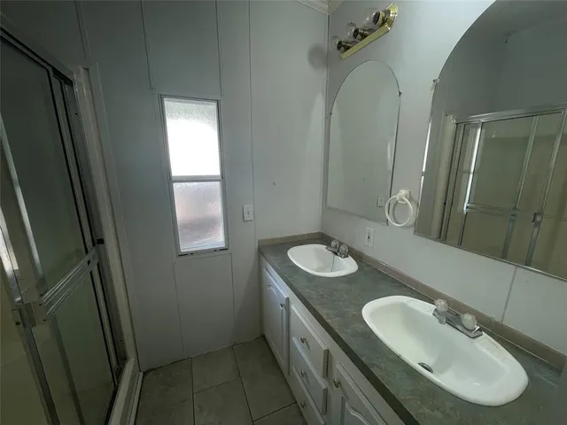 an empty room with windows and chandelier fan