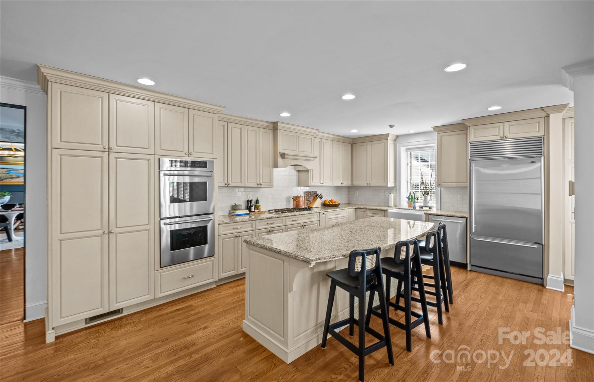 2326 Croydon Road Charlotte, NC 28207 - Photo 11 of 44 a kitchen with stainless steel appliances kitchen island granite countertop a refrigerator a stove a sink a dining table and chairs with wooden floor
