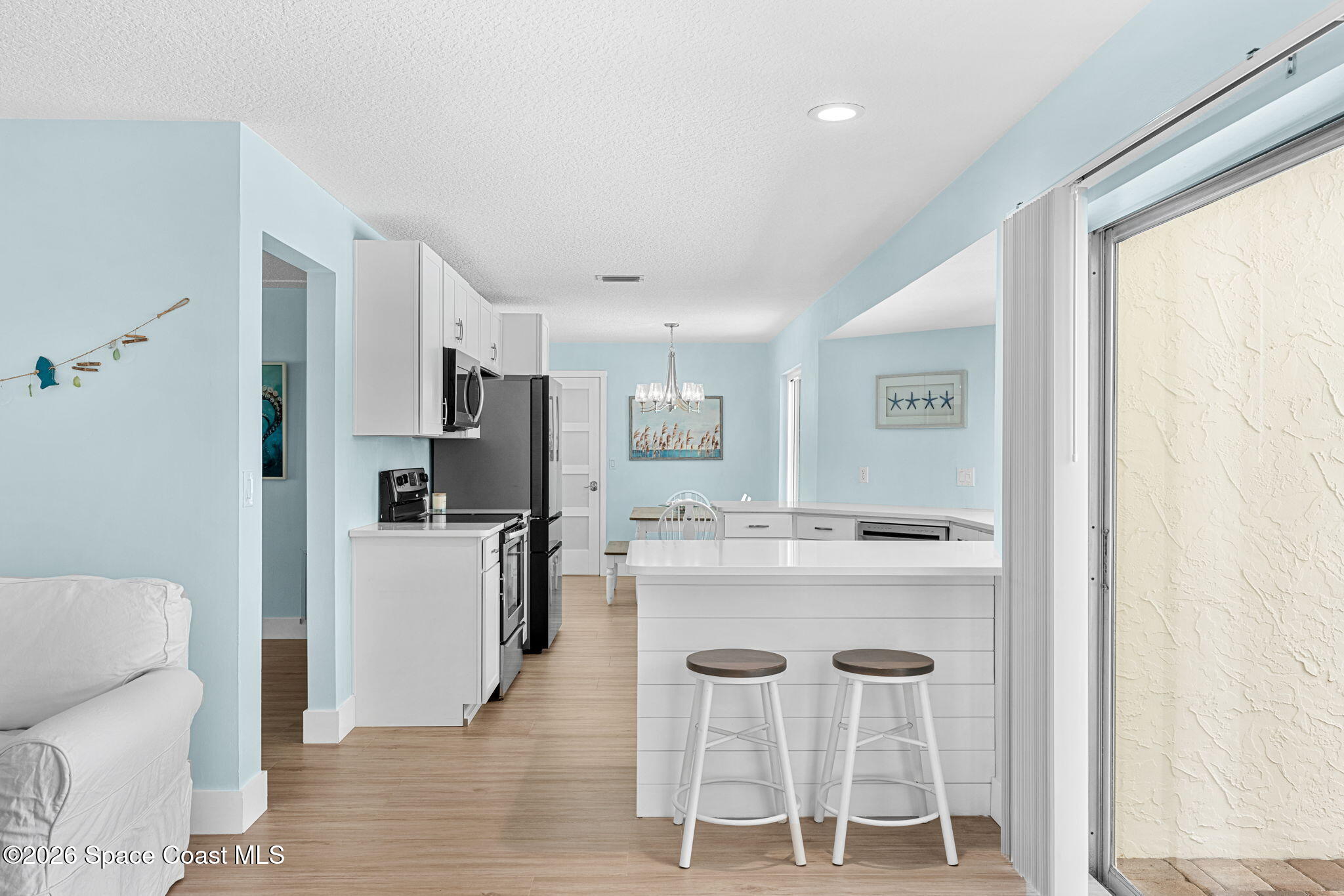 429 Rio Lane Indialantic, FL 32903 - Photo 19 of 50 a kitchen with kitchen island a refrigerator and white cabinets