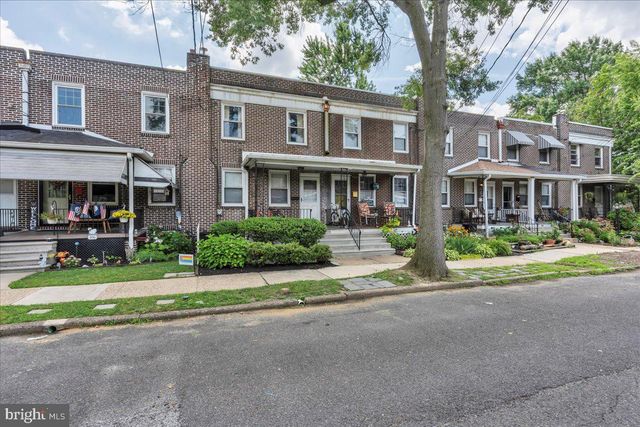 a front view of a house with a yard and potted plants
