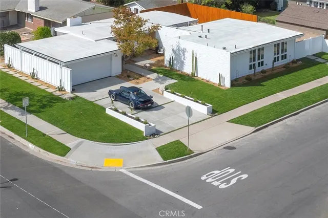 a view of a white house with a yard porch and wooden fence