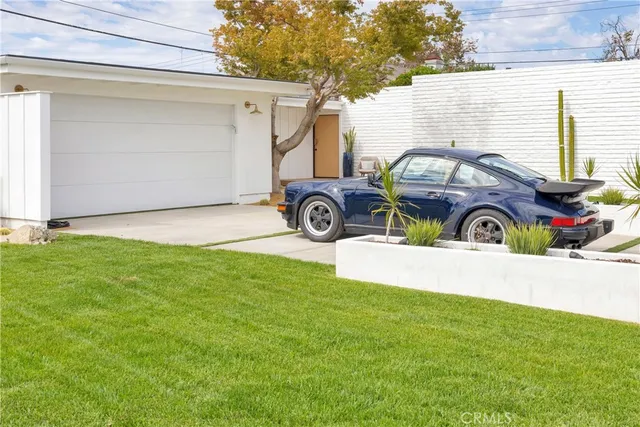 a view of front a house with a garden and parking space