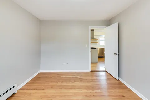 a view of a kitchen with wooden floor and a refrigerator