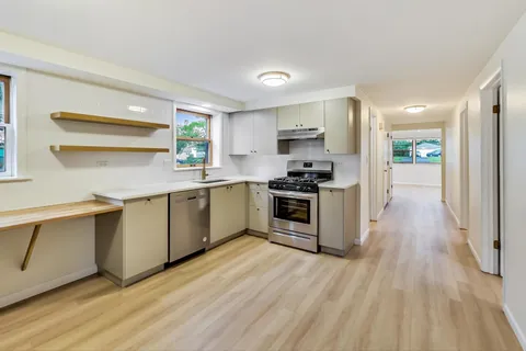 a kitchen with a sink cabinets stainless steel appliances and window