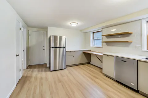 a kitchen with a refrigerator a sink and cabinets