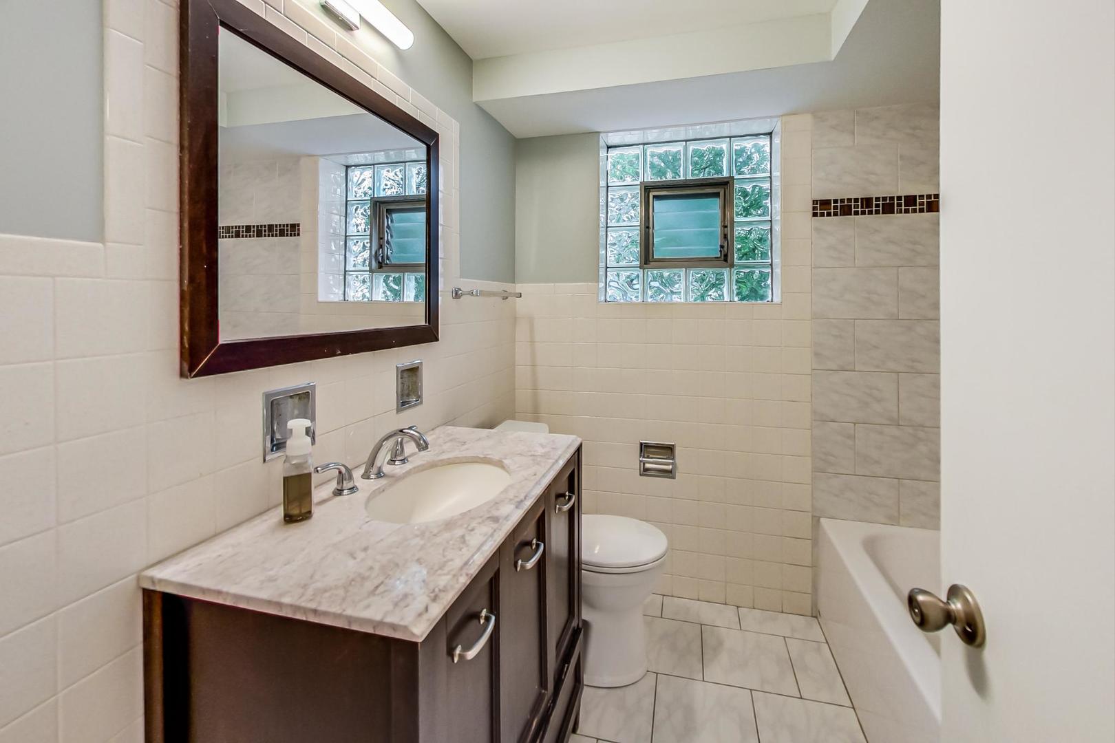 16W674 56th Place Clarendon Hills, IL 60514 - Photo 34 of 41 a bathroom with a sink a toilet and mirror